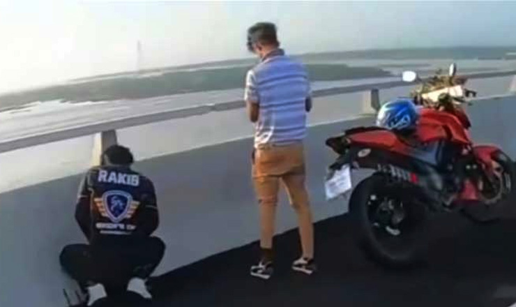 সেতুতে মূত্র বিসর্জনকারী একজনের জামার পেছনে লেখা ‘রাকিব’